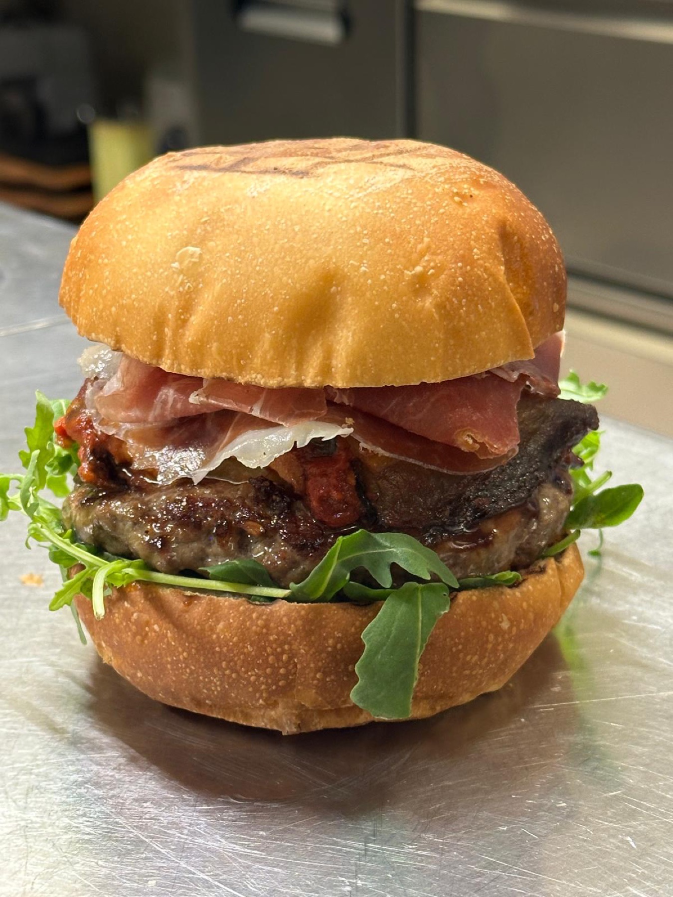 Hamburger artigianale con rucola e speck
